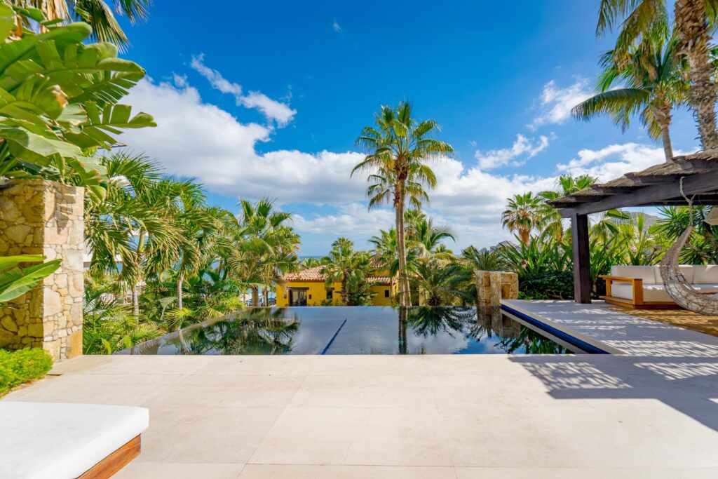Los Cabos Hacienda Csl This fully renovated three-bedroom property offers a seamless indoor-outdoor layout designed for comfortable coastal living.The private terrace features a pool, hot tub, BBQ area, and a dedicated outdoor bar, complemented by a shaded lounge and seating area surrounded by mature landscaping, ideal for entertaining or everyday relaxation. The ground-level setting allows easy access to outdoor spaces while maintaining privacy. Inside, the residence has been completely updated with clean, modern finishes and a functional floor plan. Bedrooms are well sized and thoughtfully distributed for both owners and guests. The layout includes a family suite / additional sleeping space (bunk room or flex sleeping area), allowing accommodation for up to 8 guests, offering greater flexibility than the typical 3-bedroom layout designed for six.Set in one of the most desirable areas of Cabo San Lucas, the property enjoys direct beach access and close proximity to the marina, restaurants, and services, all within the Hacienda Beach Club community. – 1102 Beachfront Hacienda, Cabo San Lucas, BS